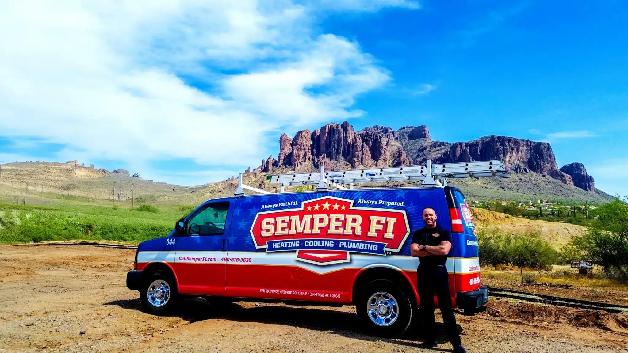 Semper Fi van parked in a desert landscape with a man standing beside it.